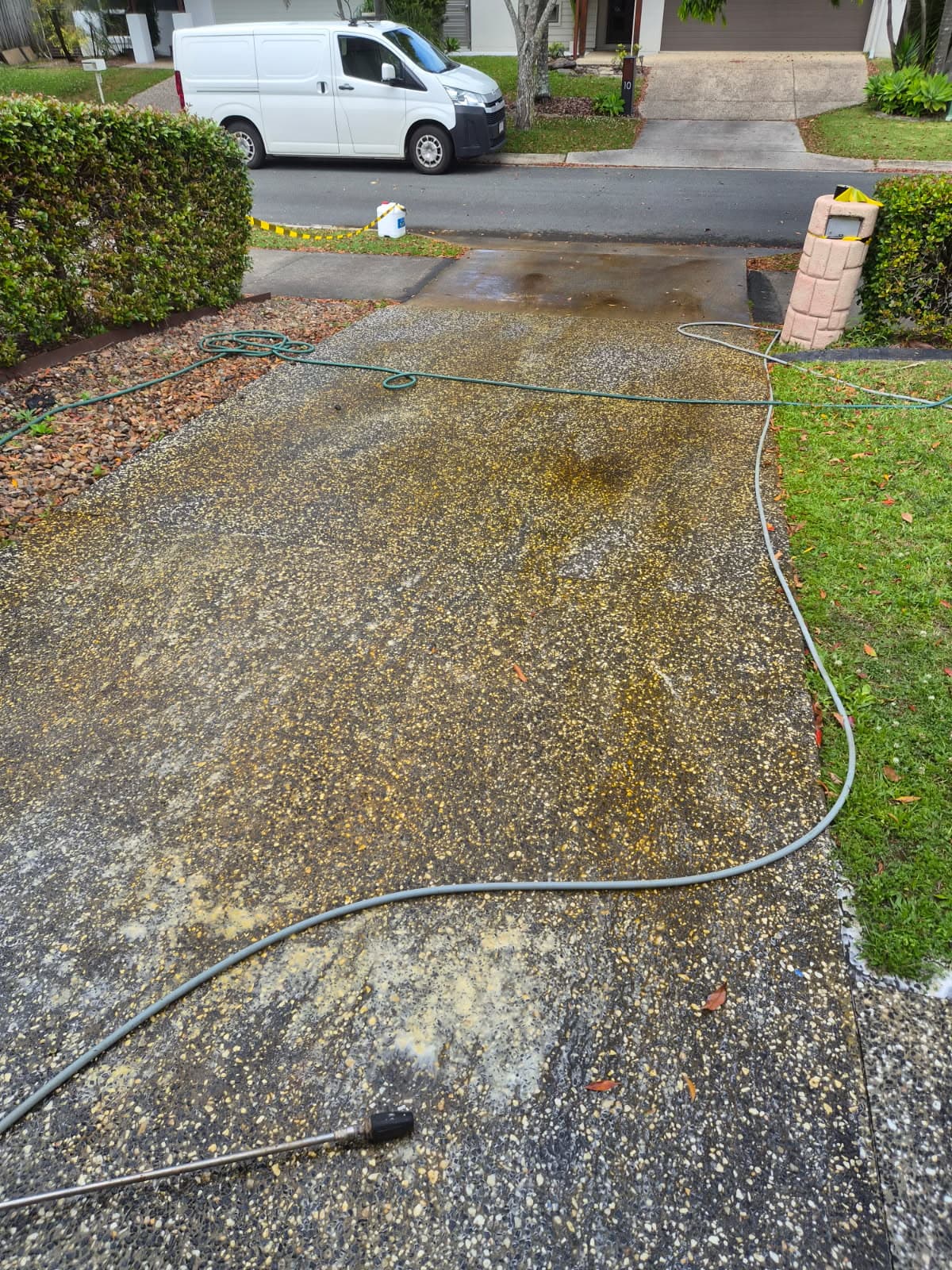 Discoloured exposed aggregate driveway before pressure cleaning